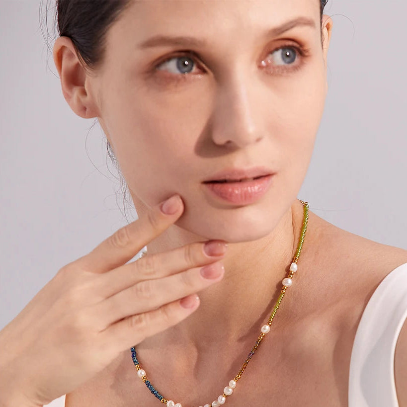 Woman wearing a pearl necklace with a neutral background