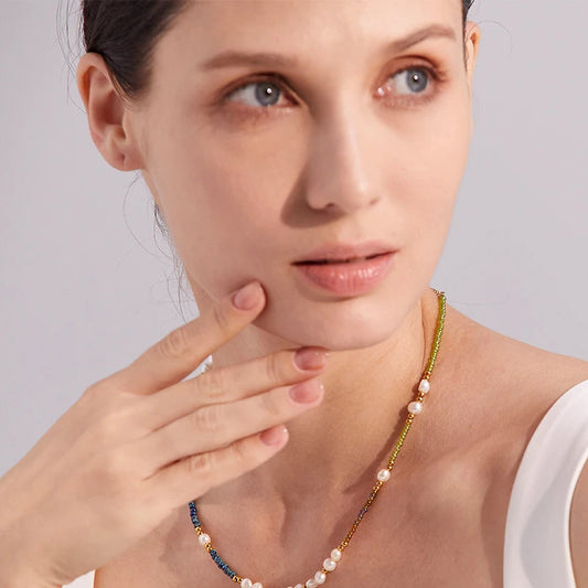 Woman wearing a pearl necklace with a neutral background