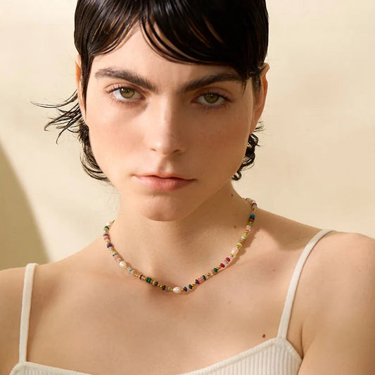 Woman wearing a necklace with a neutral background